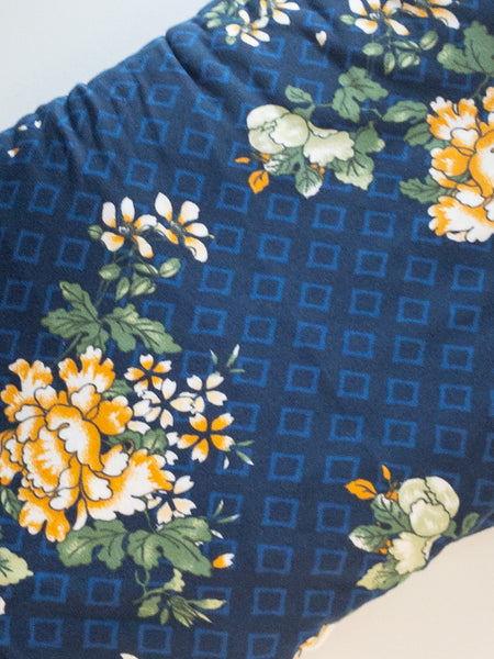 "Navy blue, light blue diamond outline shapes on double brushed polyester knit fabric, flowers are combination of golden yellow and white."